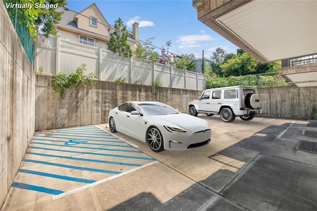 view of parking / parking lot featuring fence