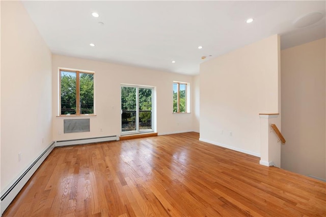 unfurnished living room with a baseboard heating unit, recessed lighting, light wood finished floors, and a baseboard radiator