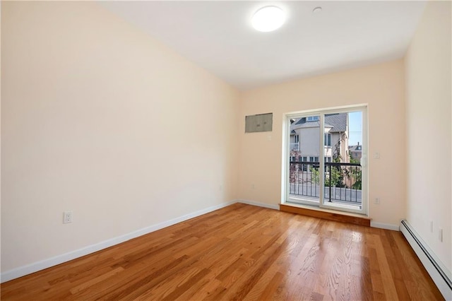 unfurnished room featuring light wood-style flooring, baseboards, and a baseboard radiator