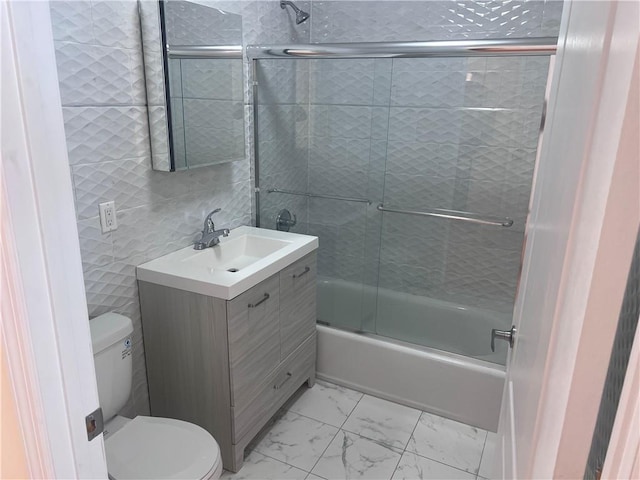 1171 86th St Unit 1B, Brooklyn, NY 11228 - full bathroom featuring vanity, combined bath / shower with glass door, marble look tiles, and tile walls