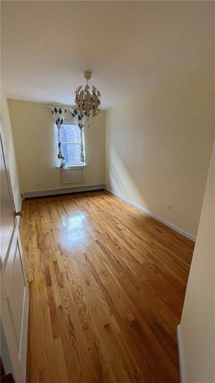 2152 81st St Unit 3A, Brooklyn, NY 11214 - unfurnished room with light wood-type flooring, a chandelier, and baseboard heating