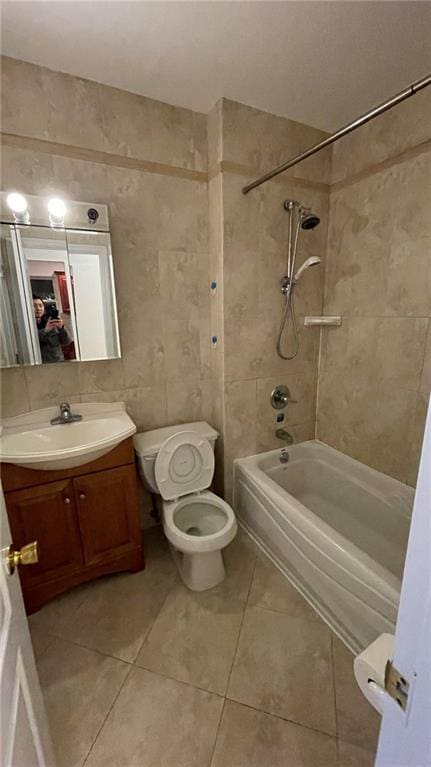 full bathroom featuring tile walls, vanity, tile patterned flooring, toilet, and tiled shower / bath