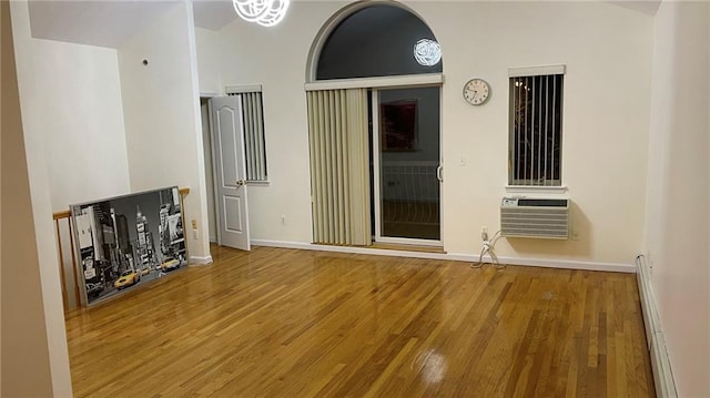2152 81st St Unit 3A, Brooklyn, NY 11214 - unfurnished living room featuring baseboard heating, an AC wall unit, and wood finished floors