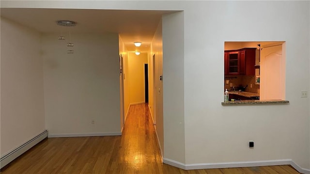 hallway featuring a baseboard radiator and hardwood / wood-style flooring