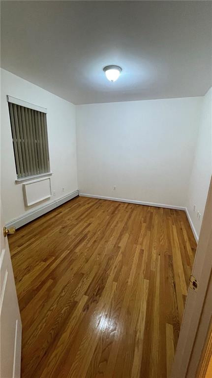 unfurnished room with hardwood / wood-style flooring