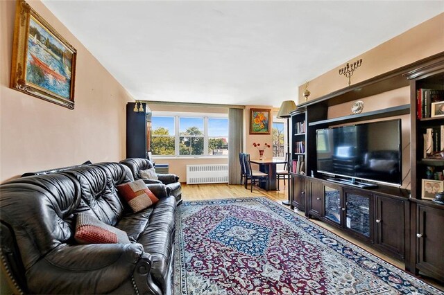 living room featuring radiator heating unit and light hardwood / wood-style floors