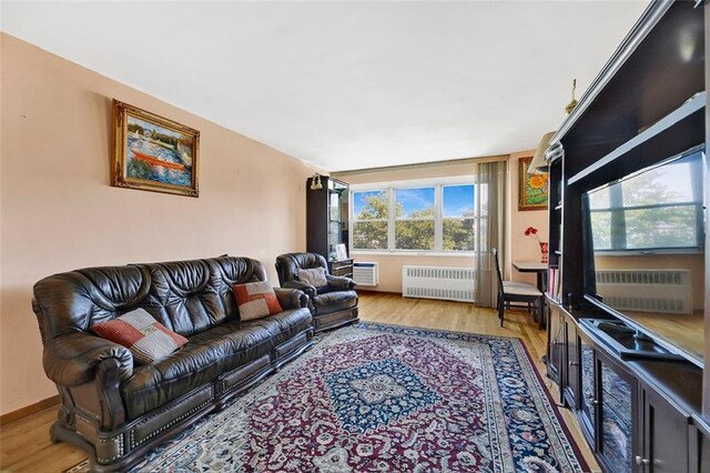 living room with radiator heating unit and light wood-type flooring