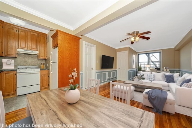 interior space featuring a ceiling fan, wood finished floors, and crown molding