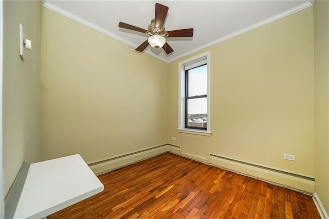 spare room with a ceiling fan, a baseboard radiator, wood-type flooring, crown molding, and baseboard heating