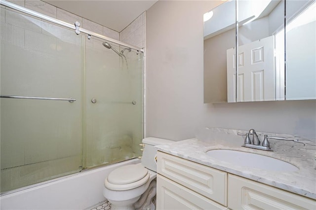 full bathroom featuring vanity, shower / bath combination with glass door, and toilet