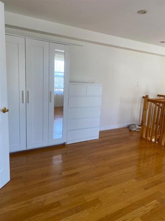 unfurnished bedroom featuring light hardwood / wood-style floors and a closet