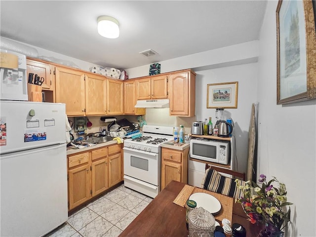 kitchen with white appliances and light brown cabinetry