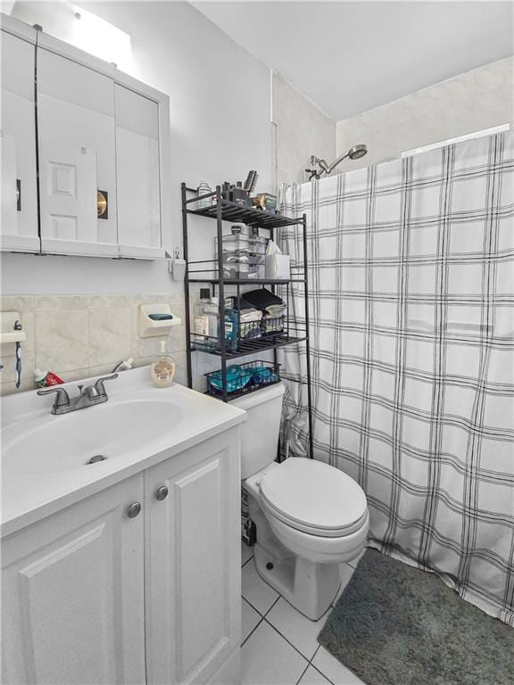 bathroom with tile patterned flooring, tile walls, vanity, curtained shower, and toilet