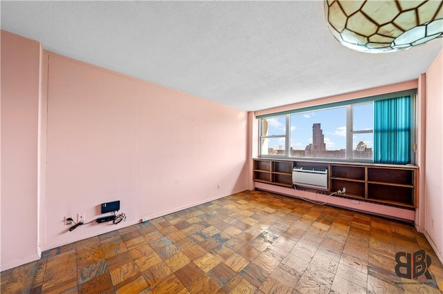 spare room featuring an AC wall unit and baseboard heating