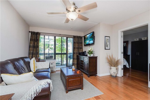 living room featuring light hardwood / wood-style floors and ceiling fan