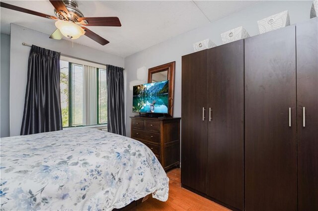 bedroom with ceiling fan and light hardwood / wood-style floors