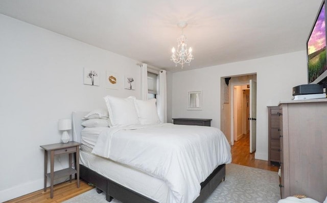 bedroom featuring a chandelier and light wood-type flooring