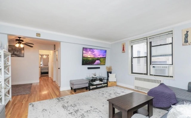 living room with radiator, ceiling fan, and light wood-type flooring