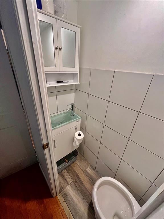 bathroom featuring hardwood / wood-style floors, vanity, tile walls, and toilet