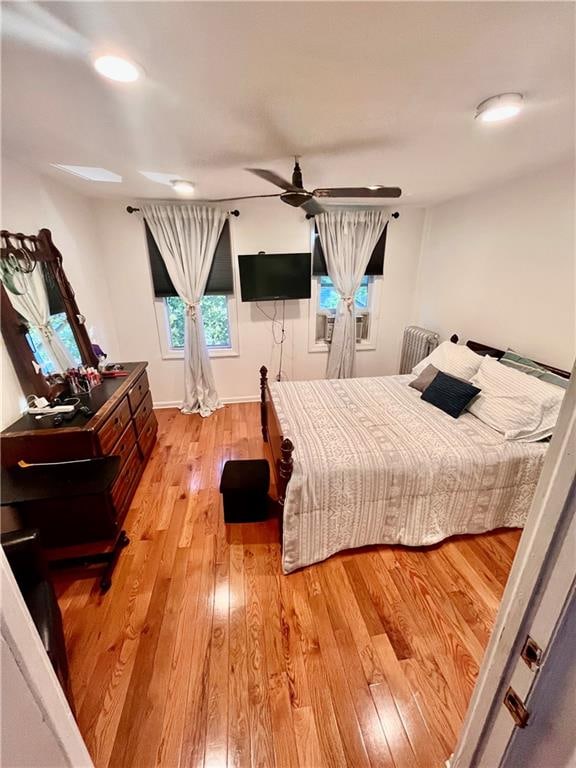 bedroom with ceiling fan and light hardwood / wood-style floors