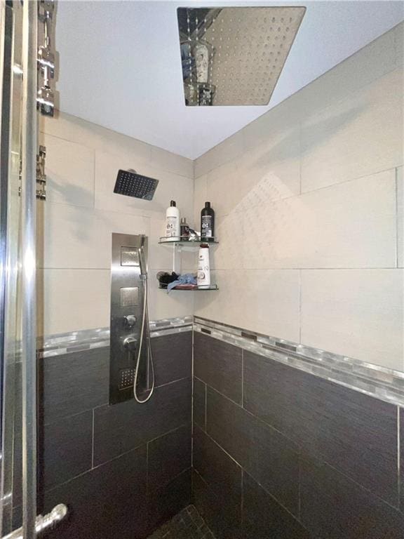 bathroom featuring walk in shower and tile walls