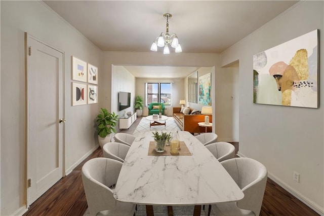 dining area featuring baseboards, a notable chandelier, and wood finished floors