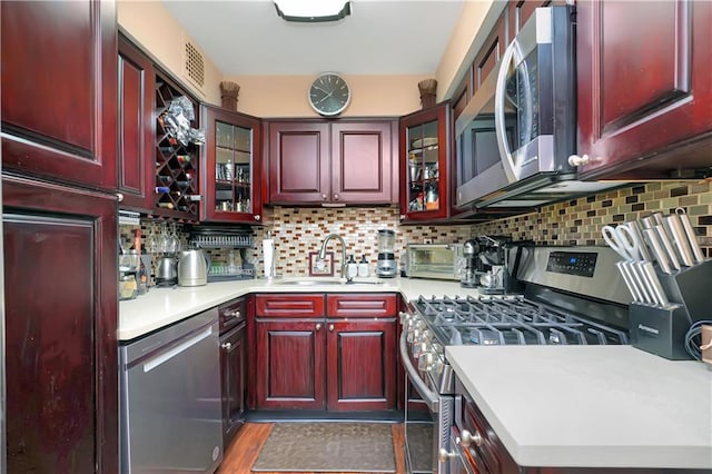 kitchen featuring tasteful backsplash, stainless steel appliances, dark hardwood / wood-style flooring, and sink