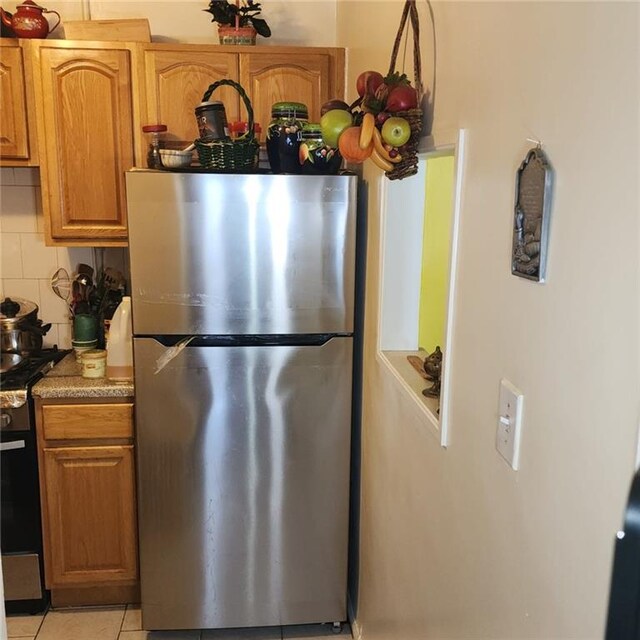 kitchen featuring appliances with stainless steel finishes, backsplash, and light tile patterned flooring