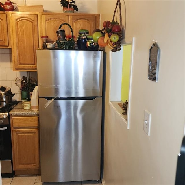 kitchen featuring appliances with stainless steel finishes, decorative backsplash, and light tile patterned floors