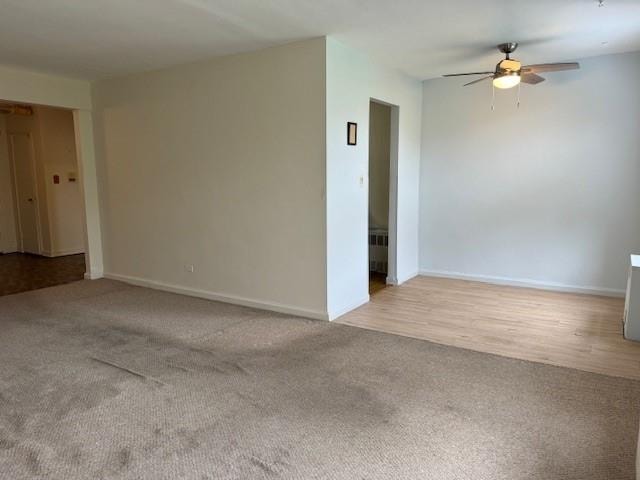 carpeted spare room featuring ceiling fan