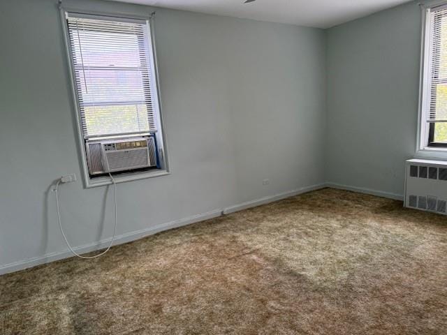 spare room featuring carpet flooring, radiator heating unit, and cooling unit