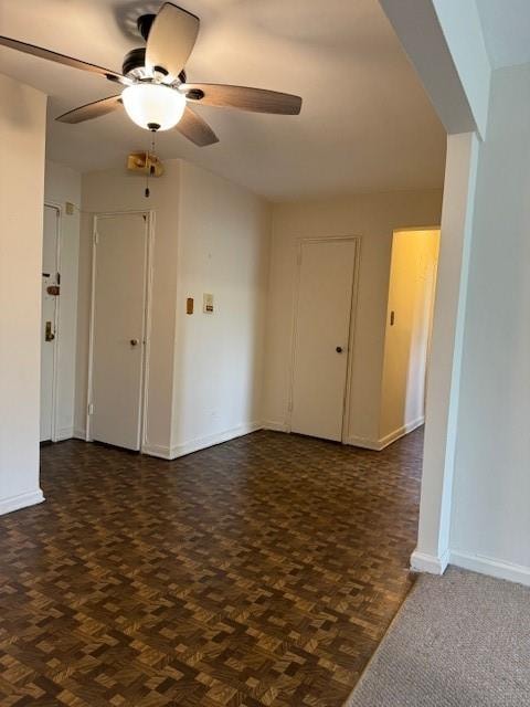 empty room featuring dark parquet flooring and ceiling fan