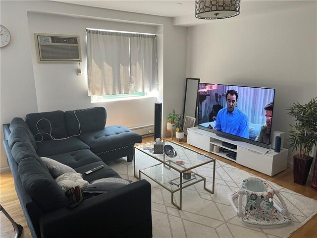 living room with a wall unit AC and hardwood / wood-style flooring