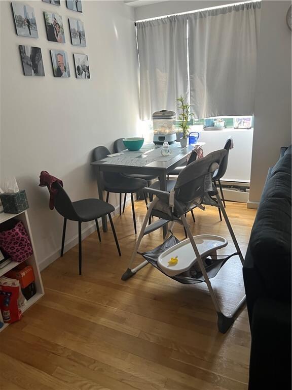 dining space with hardwood / wood-style flooring and baseboard heating