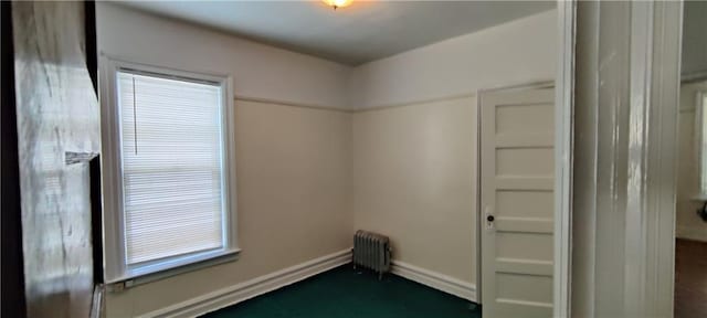 spare room with radiator heating unit and a wealth of natural light