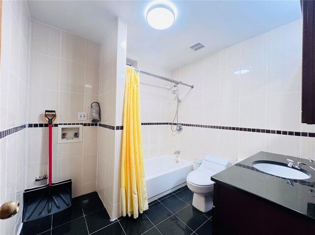 full bathroom with vanity, tile walls, toilet, tile patterned floors, and shower / bath combo