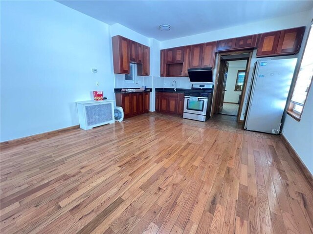 kitchen featuring light hardwood / wood-style flooring, stainless steel range oven, and refrigerator