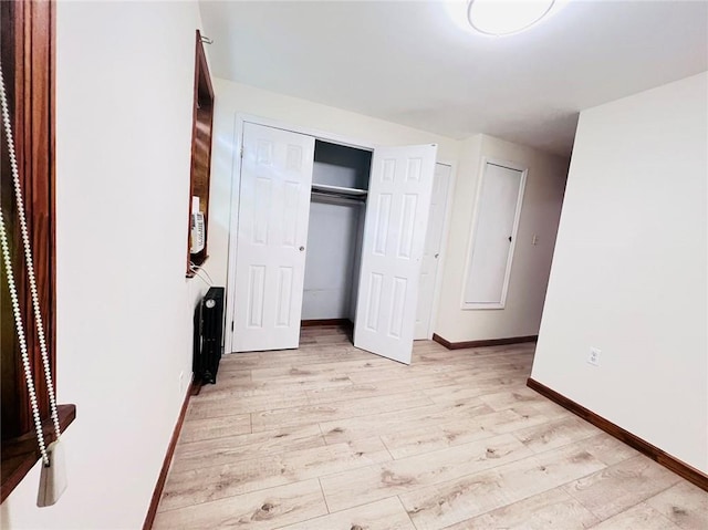 unfurnished bedroom featuring light wood-type flooring and a closet