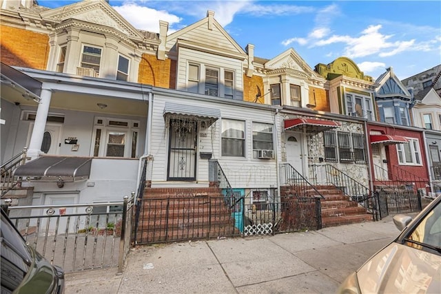 townhome / multi-family property with a fenced front yard, entry steps, a residential view, and a gate