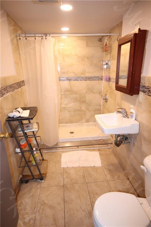 bathroom featuring walk in shower, tile walls, sink, and toilet