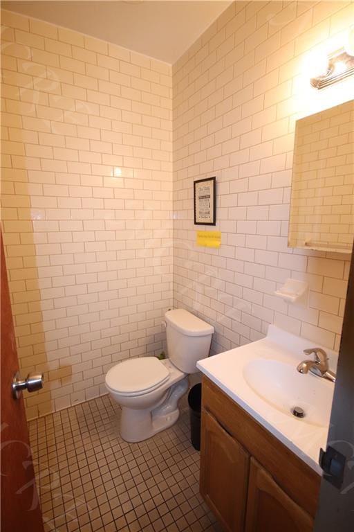 bathroom featuring vanity, tile patterned floors, toilet, and tile walls