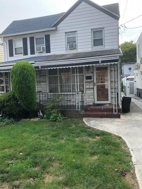 view of front of home with cooling unit and a front lawn