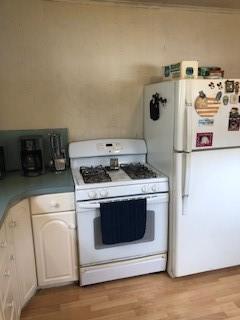 kitchen featuring ornamental molding, white cabinets, white appliances, and light hardwood / wood-style flooring