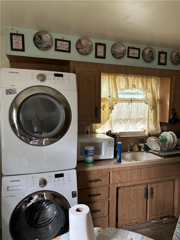 laundry room featuring stacked washer / drying machine and sink