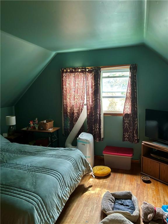 bedroom with lofted ceiling and hardwood / wood-style flooring