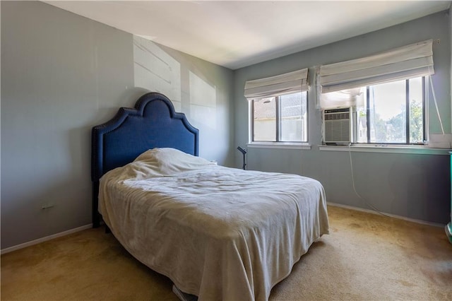 bedroom featuring light carpet, cooling unit, and baseboards