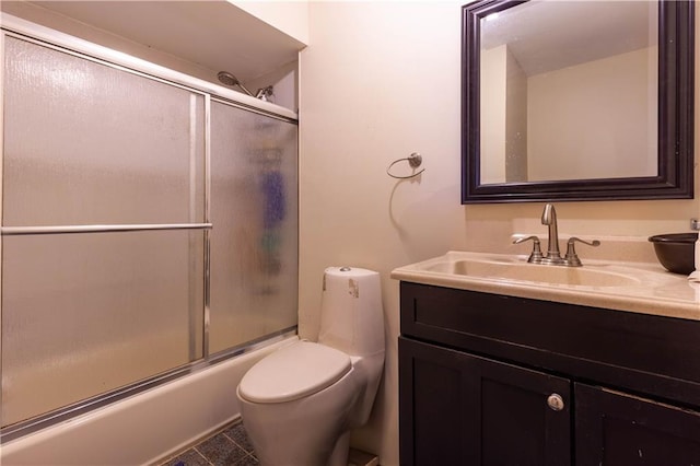 bathroom featuring toilet, vanity, and bath / shower combo with glass door