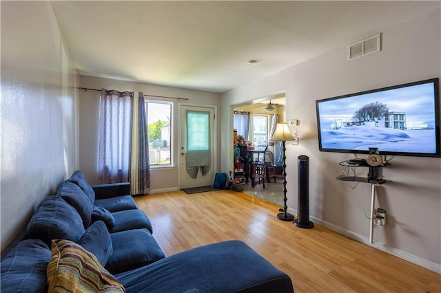 living area featuring wood finished floors, visible vents, and baseboards