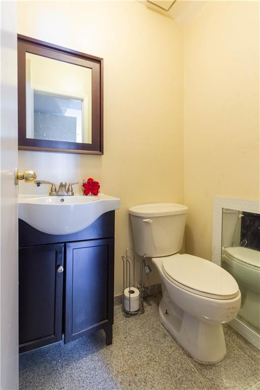 bathroom with vanity, toilet, and baseboards