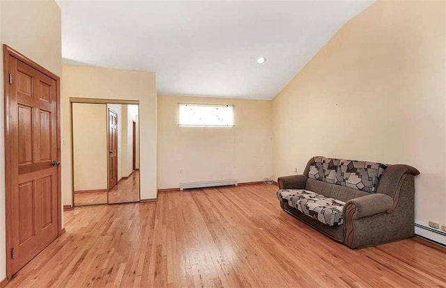 sitting room featuring vaulted ceiling, baseboard heating, and light hardwood / wood-style floors